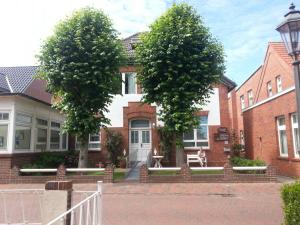 una casa con tres árboles delante de ella en Gästehaus Sophie Randa en Borkum
