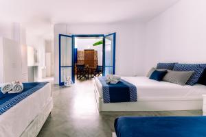 a white room with two beds and a balcony at Casa Di Roma in Parikia