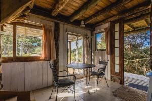 um quarto com uma mesa e cadeiras num alpendre em La Cabañita de José Ignacio em José Ignacio