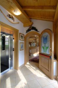 a kitchen with a stainless steel refrigerator in a room at Hotel Zoldana in Forno di Zoldo