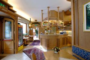 a large kitchen with a counter and tables and chairs at Hotel Zoldana in Forno di Zoldo