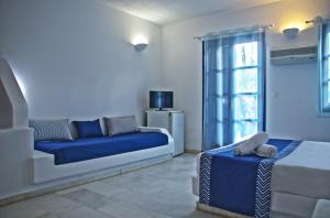 a living room with a blue couch and a window at Casa Di Roma in Parikia