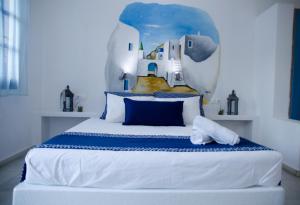 a bedroom with a large bed with a painting on the wall at Casa Di Roma in Parikia