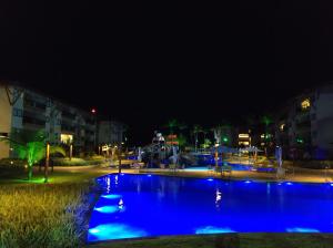 een zwembad 's nachts met blauwe lichten bij Polinésia Resort Beira Mar Muro Alto Porto de Galinhas in Porto De Galinhas