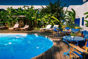 a swimming pool with tables and chairs next to a resort at Casa Di Roma in Parikia