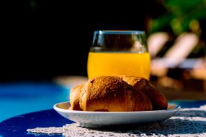 a plate of bread and a glass of orange juice at Casa Di Roma in Parikia