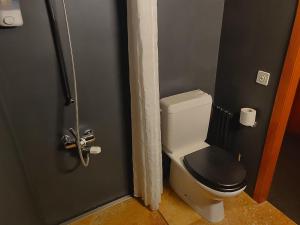 a bathroom door with a toilet with a black seat at Z Studio - next door to Vals Therme in Vals