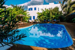 a swimming pool in front of a white building at Casa Di Roma in Parikia