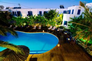 a pool in the middle of a resort with palm trees at Casa Di Roma in Parikia