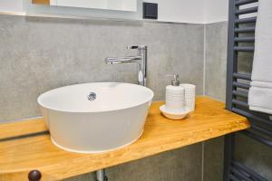 ein Badezimmer mit einem weißen Waschbecken auf einer Holztheke in der Unterkunft City Apartments Hannover in Hannover