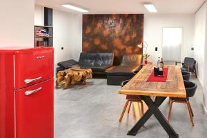 um frigorífico vermelho numa sala de estar com uma mesa em City Apartments Hannover em Hanôver