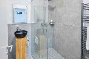a bathroom with a sink and a glass shower at City Apartments Hannover in Hannover