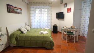 um quarto com uma cama verde e uma mesa em Naporà em Nápoles