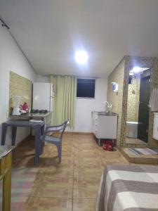 Zimmer mit einem Schreibtisch und einer Küche mit einem Waschbecken in der Unterkunft Solar boa vista in Congonhas