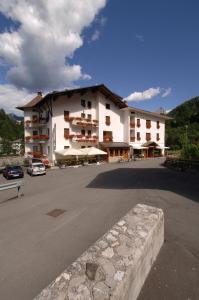 a large building with a parking lot in front of it at Hotel Zoldana in Forno di Zoldo
