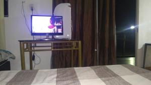 - une chambre avec un lit et une télévision sur une table dans l'établissement Solar boa vista, à Congonhas