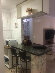 cocina con encimera con sillas y microondas en Thermas Paradise - Rio Quente - Caldas Novas, en Rio Quente