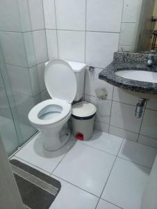 Un baño blanco con inodoro y lavabo. en Thermas Paradise - Rio Quente - Caldas Novas, en Rio Quente