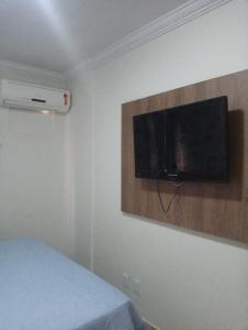 Un dormitorio con una cama y un televisor en la pared. en Thermas Paradise - Rio Quente - Caldas Novas, en Rio Quente