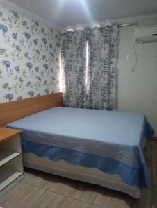 een slaapkamer met een bed met blauw en wit behang bij Thermas Paradise - Rio Quente - Caldas Novas in Rio Quente