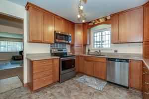 a kitchen with wooden cabinets and stainless steel appliances at Pet Friendly Sleeps 12 near Garden of the Gods AF in Colorado Springs