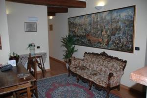 a living room with a couch and a painting on the wall at Albergo Montenerone in Piobbico