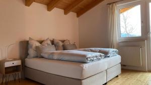 łóżko z poduszkami w pokoju z oknem w obiekcie Naturerlebnis am Glungezer-Haus-8 Pax w mieście Tulfes