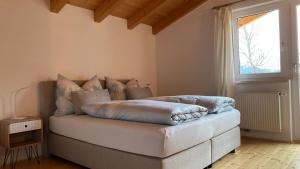 a bed with pillows on it in a room with a window at Naturerlebnis am Glungezer-Haus-8 Pax in Tulfes
