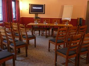 a room with a table and chairs and a television at Dovre Motell in Dovre