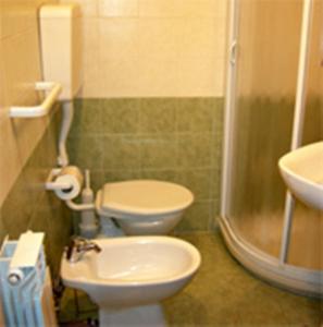 ein Badezimmer mit 2 WCs, einem Waschbecken und einer Dusche in der Unterkunft Albergo Montenerone in Piobbico