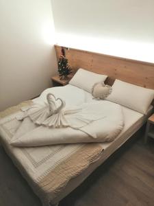 a bed with white sheets and pillows on it at LE 4 STAGIONI in Cavedago