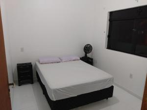 a bedroom with a bed and a flat screen tv at Apartamentos Praia do Sonho in Palhoça