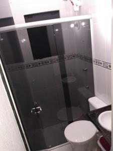 ein Bad mit einer Dusche, einem WC und einem Waschbecken in der Unterkunft Apartamentos Praia do Sonho in Palhoça