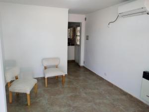 Zimmer mit 2 Stühlen und einer weißen Wand in der Unterkunft Departamento Colón 1 in San Rafael