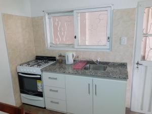 eine Küche mit einer Spüle, einem Herd und einem Fenster in der Unterkunft Departamento Colón 1 in San Rafael