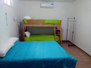 ein Schlafzimmer mit einem Etagenbett und einem grünen Bett in der Unterkunft Departamento Colón 1 in San Rafael