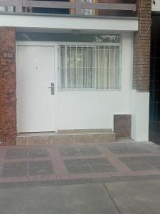 una puerta de garaje blanca en un edificio de ladrillo en Departamento Colón 1, en San Rafael