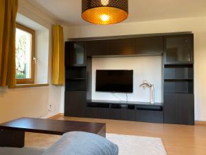 a living room with a large black entertainment center at Wohne im Grünen/Innsbruck/4 Pax in Innsbruck