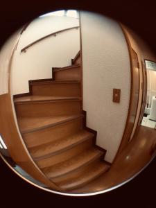 a reflection of a staircase in a circular mirror at 京樽5号 1棟貸切 一軒家 4-Bedrooms Duplex Private Villa KYOTARU5 in Otaru +9 photos