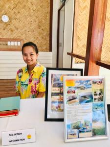 a woman sitting at a table next to a table with a sign at Mariejoy Haven Beach Resort in San Vicente