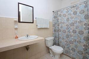 uma casa de banho com um WC, um lavatório e um espelho. em Casa de Ana - Habitación privada em Cancún