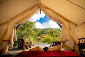 a tent with a bed and a view of a mountain at Quinta Alma - Ecological Retreat Farm in Aljezur