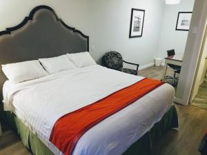 1 dormitorio con 1 cama grande con manta naranja en Ace Motel, en Princeton
