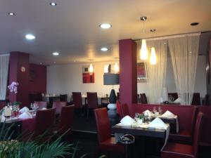 a dining room with tables and chairs in a restaurant at L'Ecailler in Ouistreham