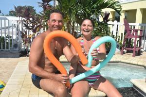 een man en een vrouw naast een zwembad bij Beachfront Bliss Villas in Clearwater Beach