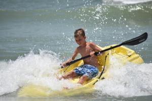 een jonge jongen op een kajak in het water bij Beachfront Bliss Villas in Clearwater Beach