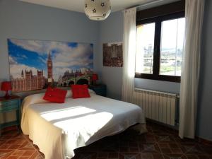 Un dormitorio con una cama con almohadas rojas. en Hotel Rural La Casa del Tio Telesforo, en Trescasas