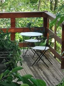 una mesa y sillas en una terraza de madera en Bungalow Maelie, en La Trinité