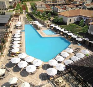 een uitzicht over een zwembad met parasols en stoelen bij Apollonion Asterias Resort and Spa in Xi