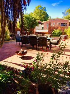 a patio with chairs and a table and flowers at Bakery Park Motor Inn in Tocumwal